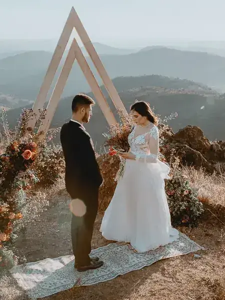 Casamento ao ar livre na serra com arco de madeira, em Minas Gerais
